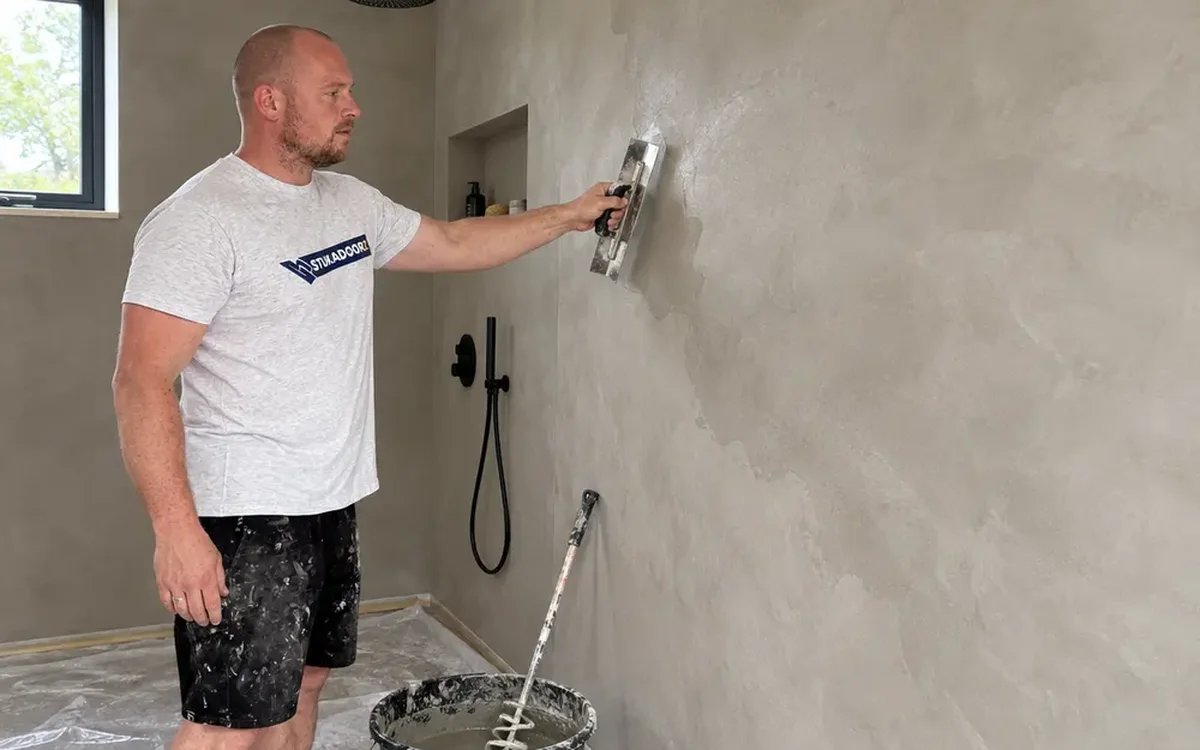 Stukadoor van Stukadoorz brengt een decoratieve wandafwerking aan in een badkamer