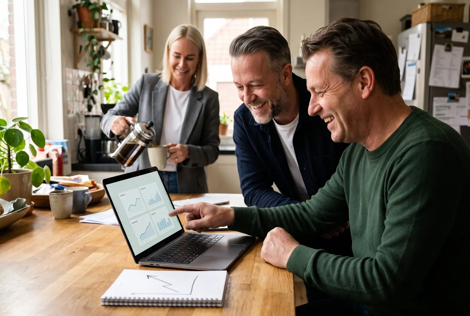 Voorbeeldfoto, met AI gemaakt: Maurice van Advertise Experts bekijkt met een ondernemer aan zijn keukentafel het dashboard op de laptop, Linda schenkt koffie in